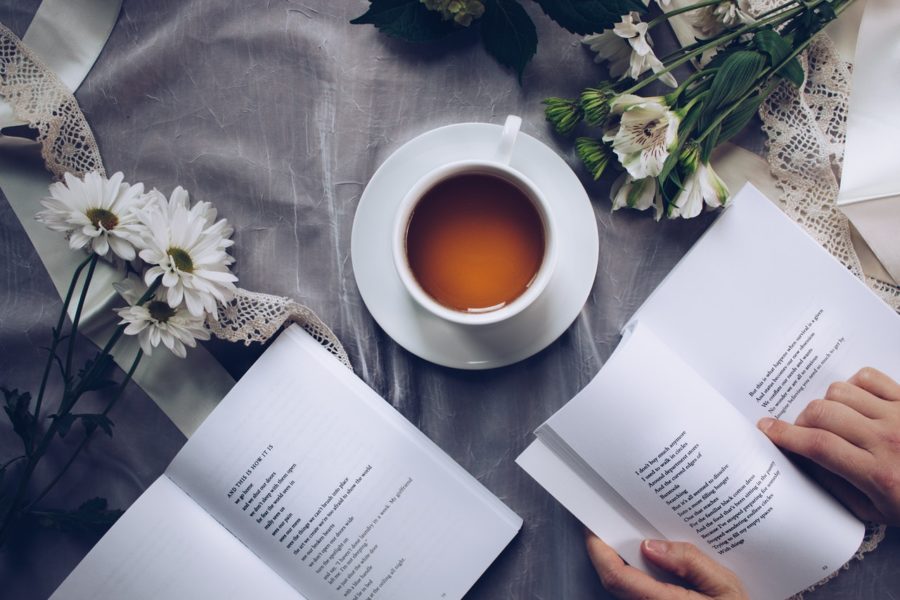 A cup of tea, books, and flowers.