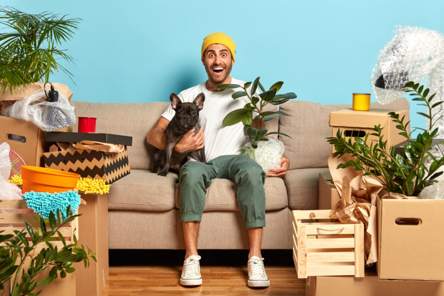 An excited man sitting on a couch with a dog
