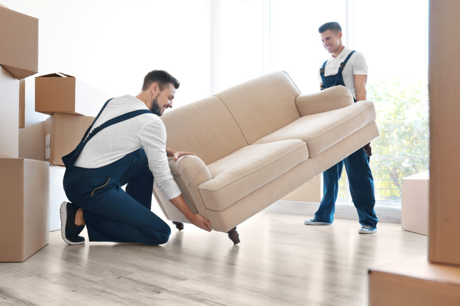Two movers lifting a couch