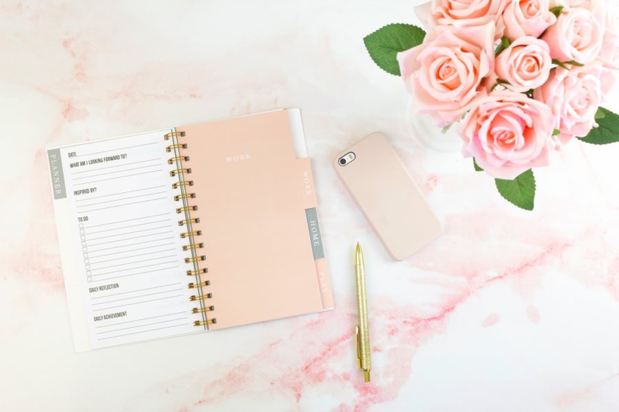 Pink notebook next to roses and phone
