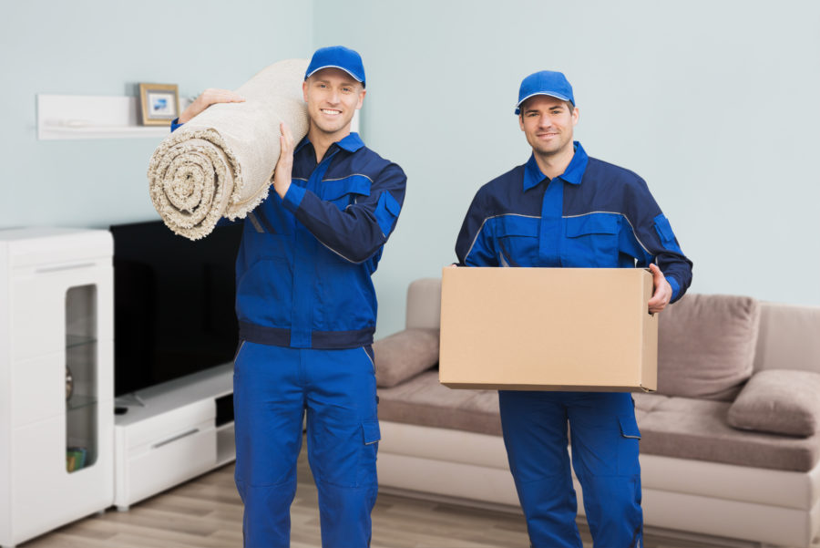 Professional movers carrying a rug and cardboard package